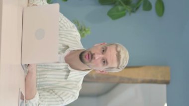 Bilgisayarı kullanırken Genç Adam 'ın Kameraya Bakışının Dikey Videosu