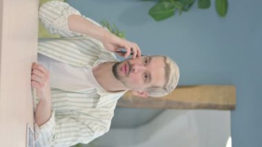 Ofiste Genç Adam 'ın telefonda konuştuğu dikey video.