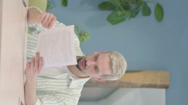 Belgeleri okurken Genç Adam 'ın Şok Olduğu Dikey Video