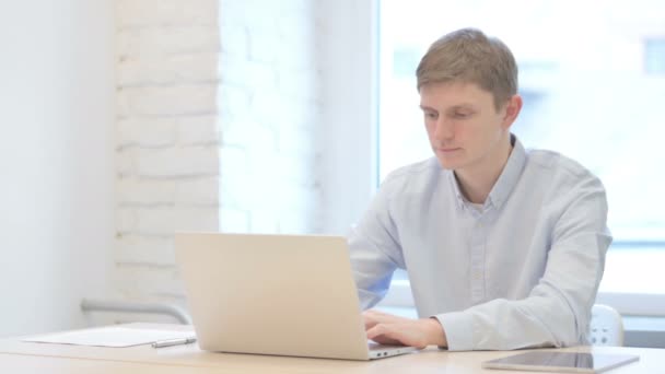 Νεαρός Επιχειρηματίας Πληκτρολογώντας Στο Laptop Στο Office — Αρχείο Βίντεο