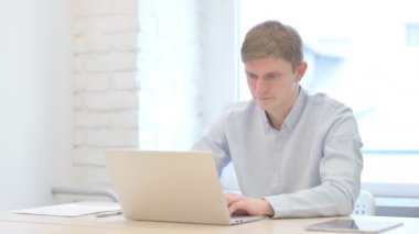 Young Businessman Coughing while Working on Laptop