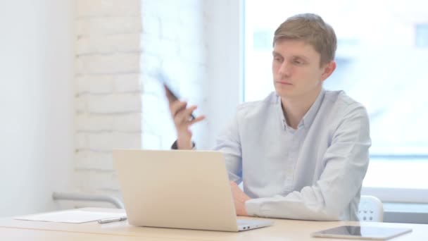 Молодой Бизнесмен Разговаривает Телефону Время Использования Ноутбука — стоковое видео