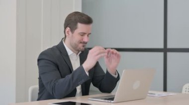 İşadamı dizüstü bilgisayarla uğraşırken baş ağrısı çekiyor