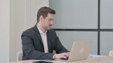 İşadamı dizüstü bilgisayar kullanırken boyun ağrısı çekiyor