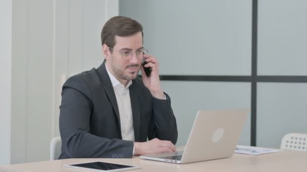 Бізнесмен Розмовляє Телефону Під Час Використання Ноутбука — стокове відео