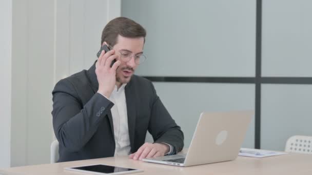 Unzufriedener Geschäftsmann Spricht Bei Der Arbeit Wütend Auf Smartphone — Stockvideo