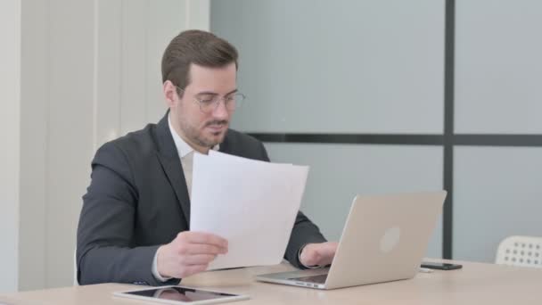 Üzletember Ünnepli Sikert Miközben Dolgozik Laptop Dokumentumok — Stock videók
