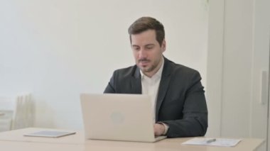 İşadamı dizüstü bilgisayarda çalışırken öksürüyor