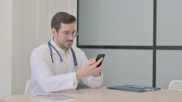 医生在诊所浏览智能电话 — 图库视频影像
