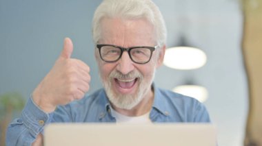 Close Up of Thumbs Up by Senior Old Man Working on Laptop
