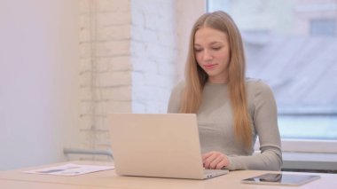 Dizüstü bilgisayarda çalışan yaratıcı genç kadın.