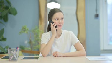 Young Woman Talking on Phone Discussing