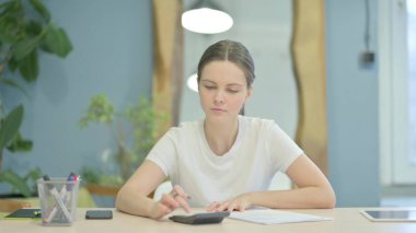 Young Woman Doing Calculations at Work