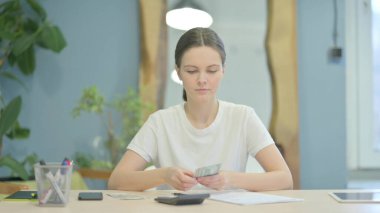 Young Woman Doing Calculations at Work