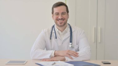 Doktor Klinikte Otururken Kameraya Gülümsüyor