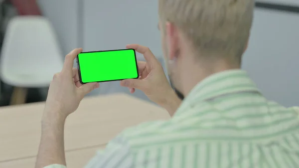 Человек Держит Горизонтальный Смартфон Зеленым Экраном — стоковое фото
