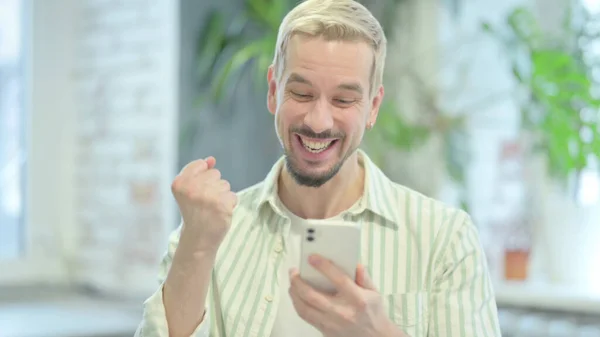 Modern Genç Adam Akıllı Telefonla Zaferi Kutluyor — Stok fotoğraf