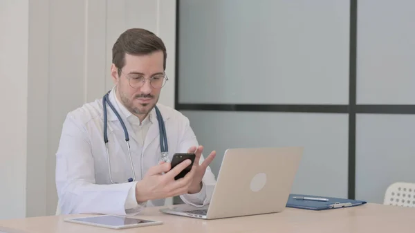 Lekarz Korzystający Smartfona Podczas Korzystania Laptopa — Zdjęcie stockowe