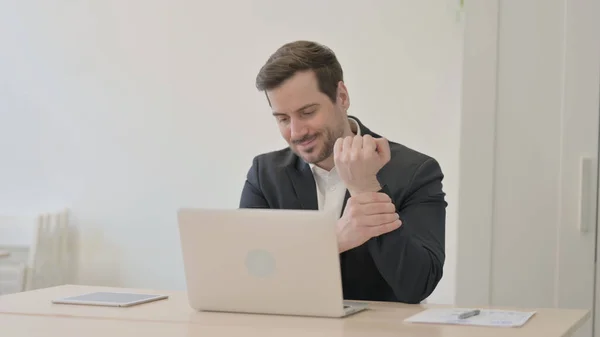 Businessman Having Wrist Pain While Using Laptop — Stock Photo, Image