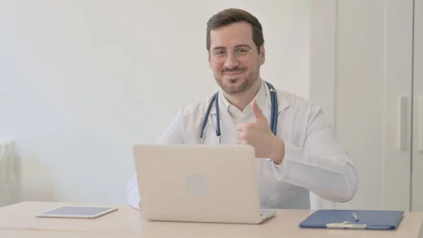 ノートパソコンで働く医師による親指アップ — ストック写真