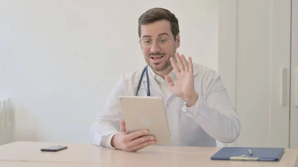 医師がタブレット経由でオンラインビデオチャットを行う — ストック写真