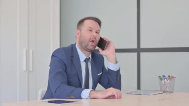 smartphone üzerinde konuşan işadamı