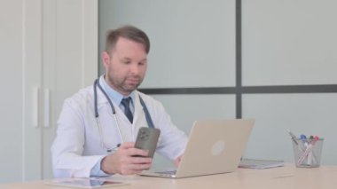 Genç Doktor Laptop ve Akıllı Telefon Üzerinde Çalışıyor