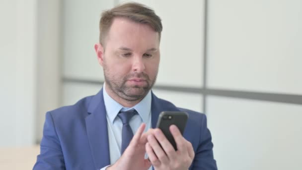 スマートフォンを使った陽気なビジネスマンの肖像 — ストック動画