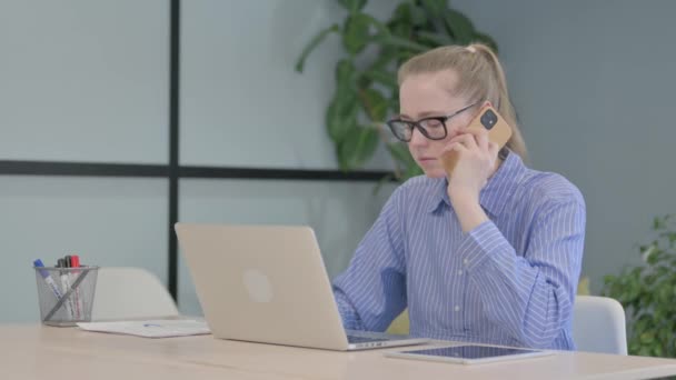 Νεαρή Γυναίκα Μιλάει Στο Τηλέφωνο Στη Δουλειά — Αρχείο Βίντεο