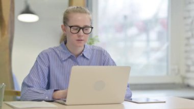 Thumbs Down by Young Woman Working on Laptop