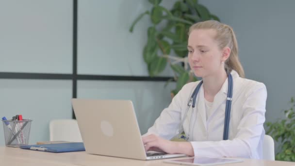 女医生在手提电脑上工作时在相机前微笑 — 图库视频影像