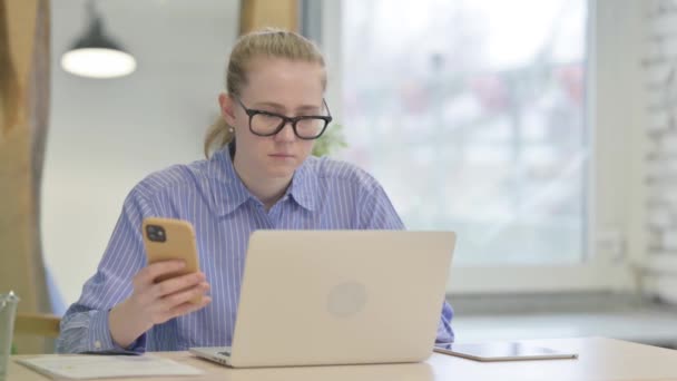 Mladá Žena Pracující Notebooku Pomocí Chytrého Telefonu — Stock video