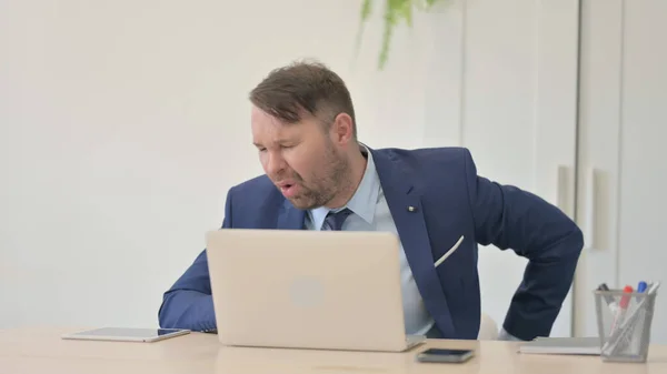 Businessman with Wrist Pain Working on Laptop