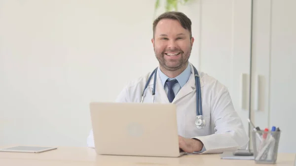 Νέος Γιατρός Χαμογελώντας Στην Κάμερα Ενώ Εργάζονται Φορητό Υπολογιστή — Φωτογραφία Αρχείου
