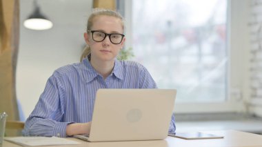 İş yerindeki kameraya doğru bakan Ciddi Genç Kadın