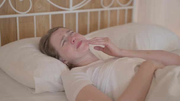 有牙痛的年轻妇女躺在床上 — 图库视频影像