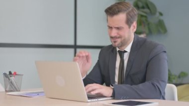 Young Businessman with Neck Pain Working on Laptop