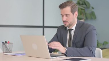 Young Businessman with Headache Working on Laptop