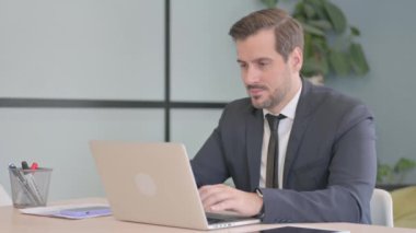 Genç İşadamı Bilgisayarda Çalışırken Kameraya Gülümsüyor