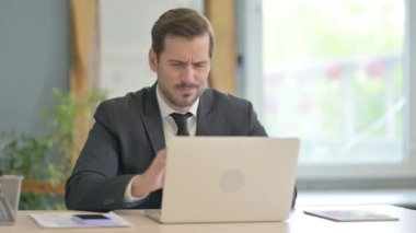 Young Businessman with Neck Pain Working on Laptop