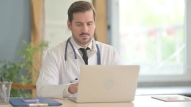Genç Erkek Doktor Klinikte Dizüstü bilgisayarda çalışıyor