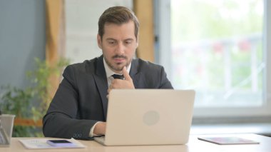 Düşünme ve dizüstü bilgisayarda çalışan iş adamı