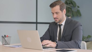 dizüstü bilgisayarda çalışan meşgul işadamı