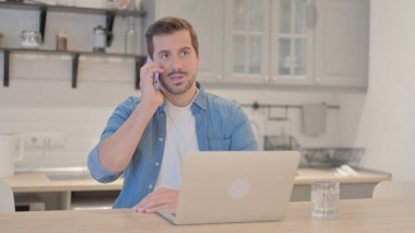 Genç adam iş yerinde konuşuyor.