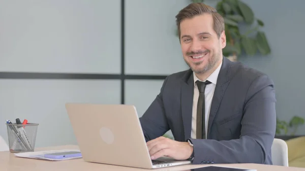 Geschäftsmann Lächelt Während Der Arbeit Laptop Die Kamera — Stockfoto