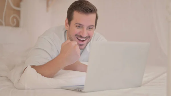 Fiatalember Ünnepli Sikert Laptopon Miközben Fekszik Gyomor Ágyban — Stock Fotó