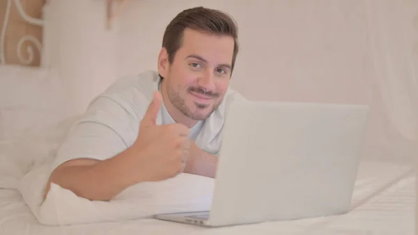 Ung Man Gör Tummar Upp När Använder Laptop Ligger Mage — Stockfoto