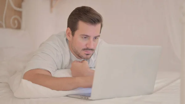 Fiatal Férfi Dolgozik Laptop Miközben Feküdt Gyomor Ágyban — Stock Fotó