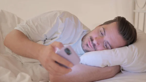 Молодой Человек Использует Телефон Лежа Кровати Обочине — стоковое фото