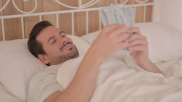 Junger Mann Beim Geldzählen Bett — Stockfoto